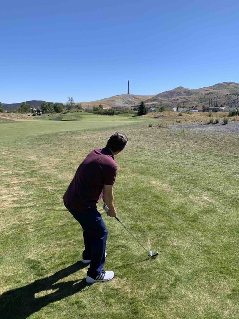 old works golf club with smelter chimney in the distance